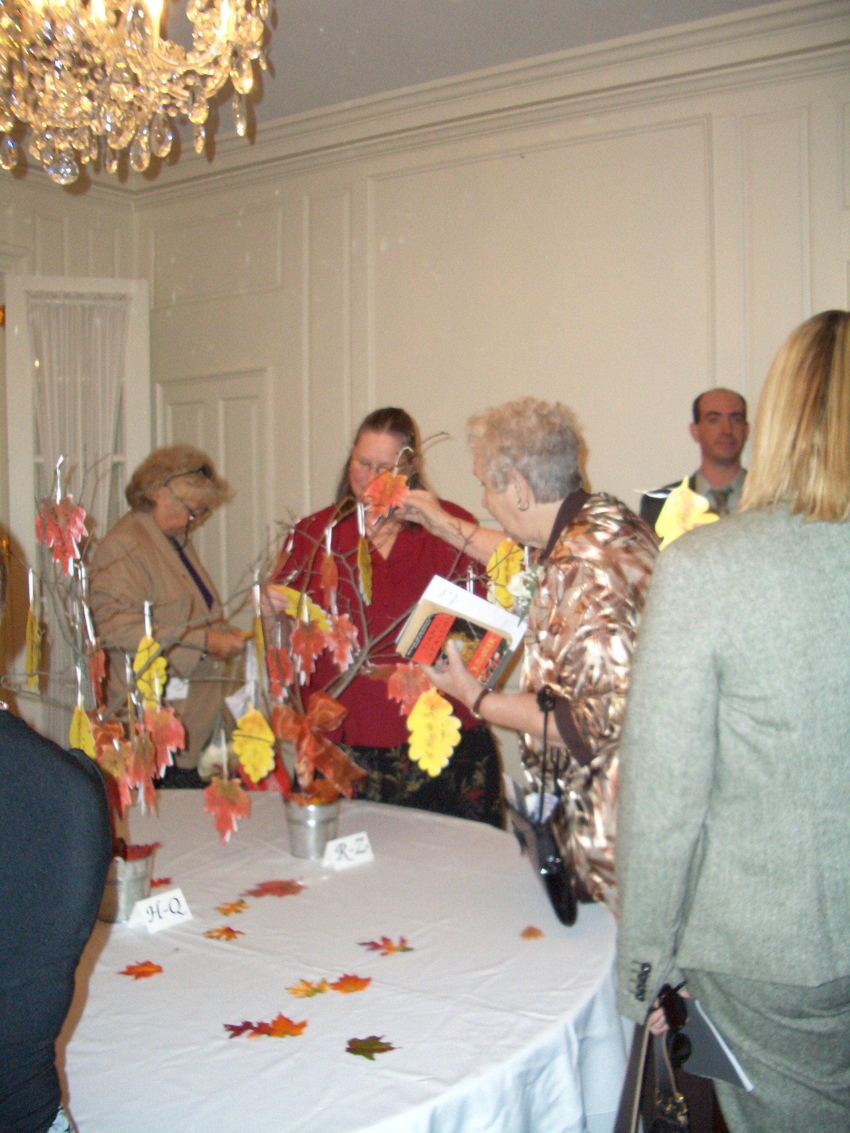 Guest pulling thier leaf shaped seating card from the little trees Marie made.